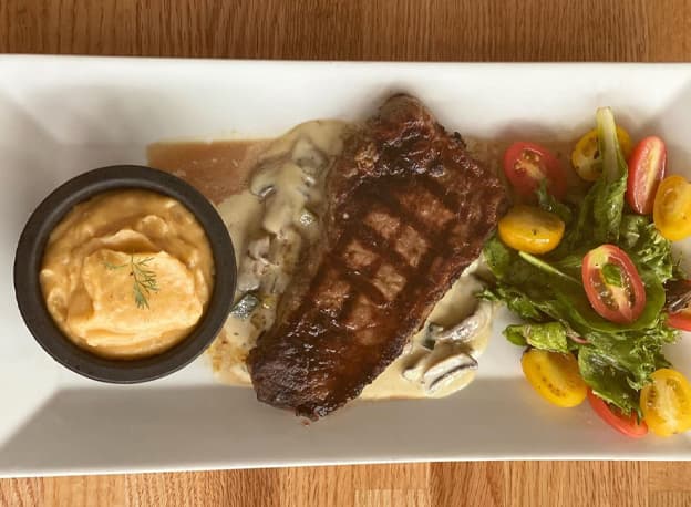 NY Steak recipe served on a plate, by Casa Villa Restaurant
