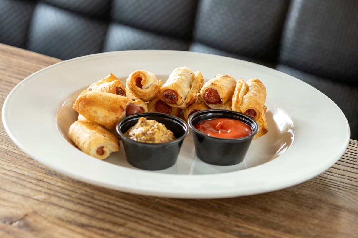 Pigs in a Blanket recipe served on a plate, by Cavo's Bar & Kitchen