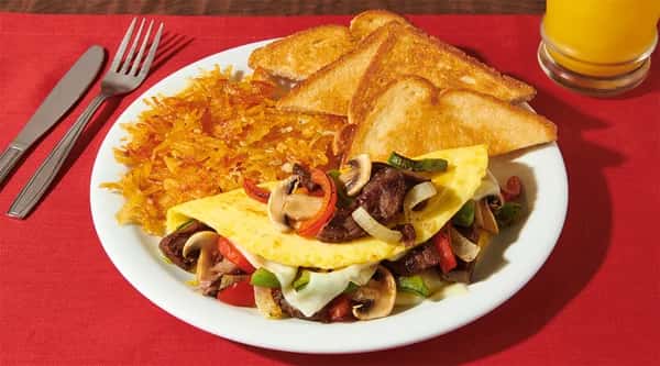Philly Cheesesteak Omelette recipe served on a plate, by Denny's Philly Cheesesteak Omelette recipe served on a plate, by Denny's